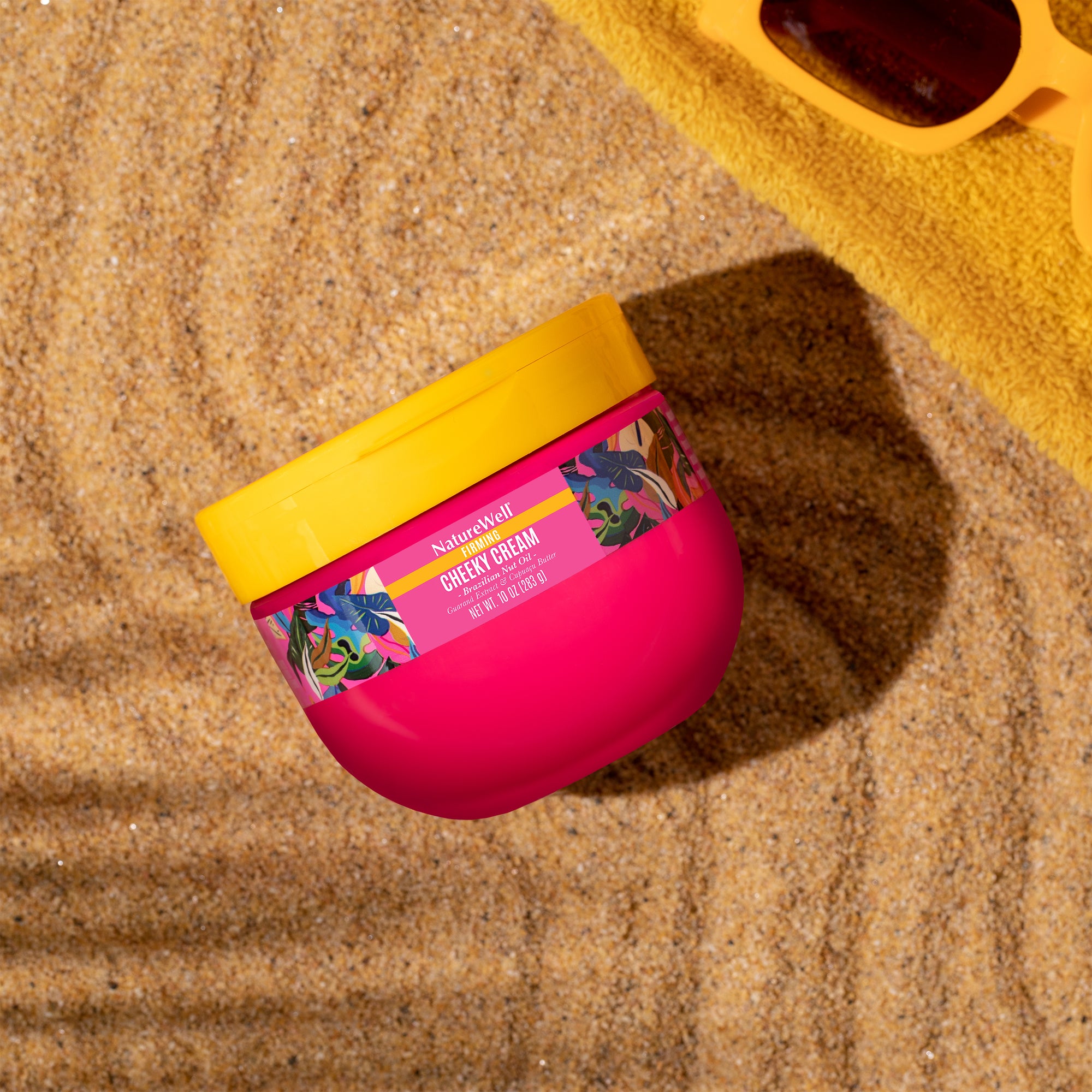 jar of firming body cream featured in a beach setting