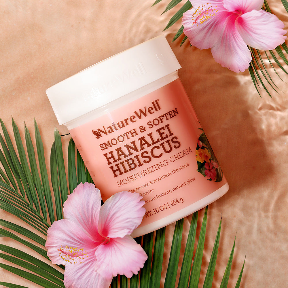 jar of hibiscus scented body cream featured in a beach setting with hibiscus flowers