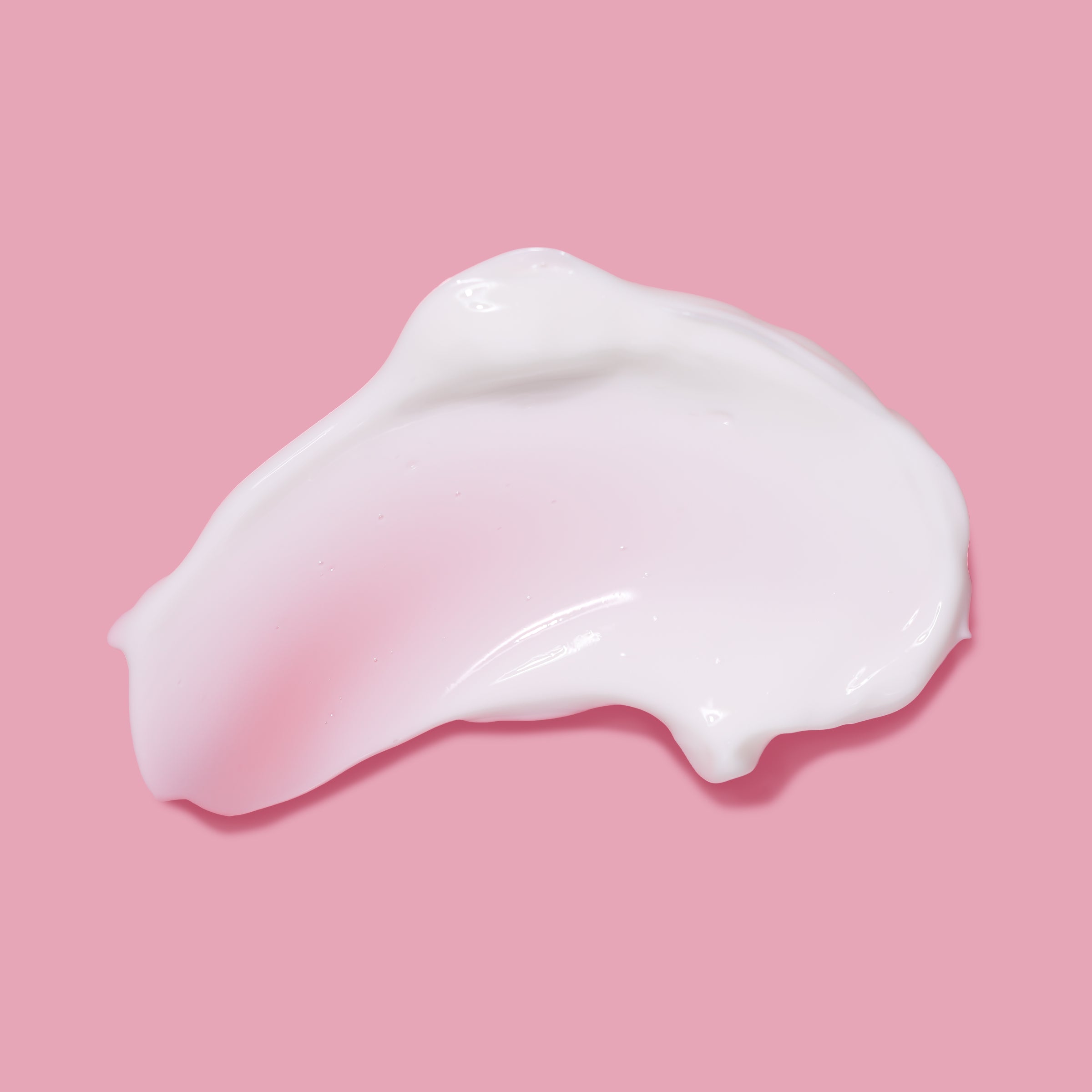 Swatch of product of NatureWell Bouncy Plumping Body Cream on a pink background