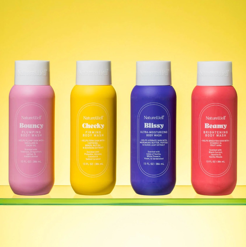 Assortment of four bottles of NatureWell body washes on a yellow background