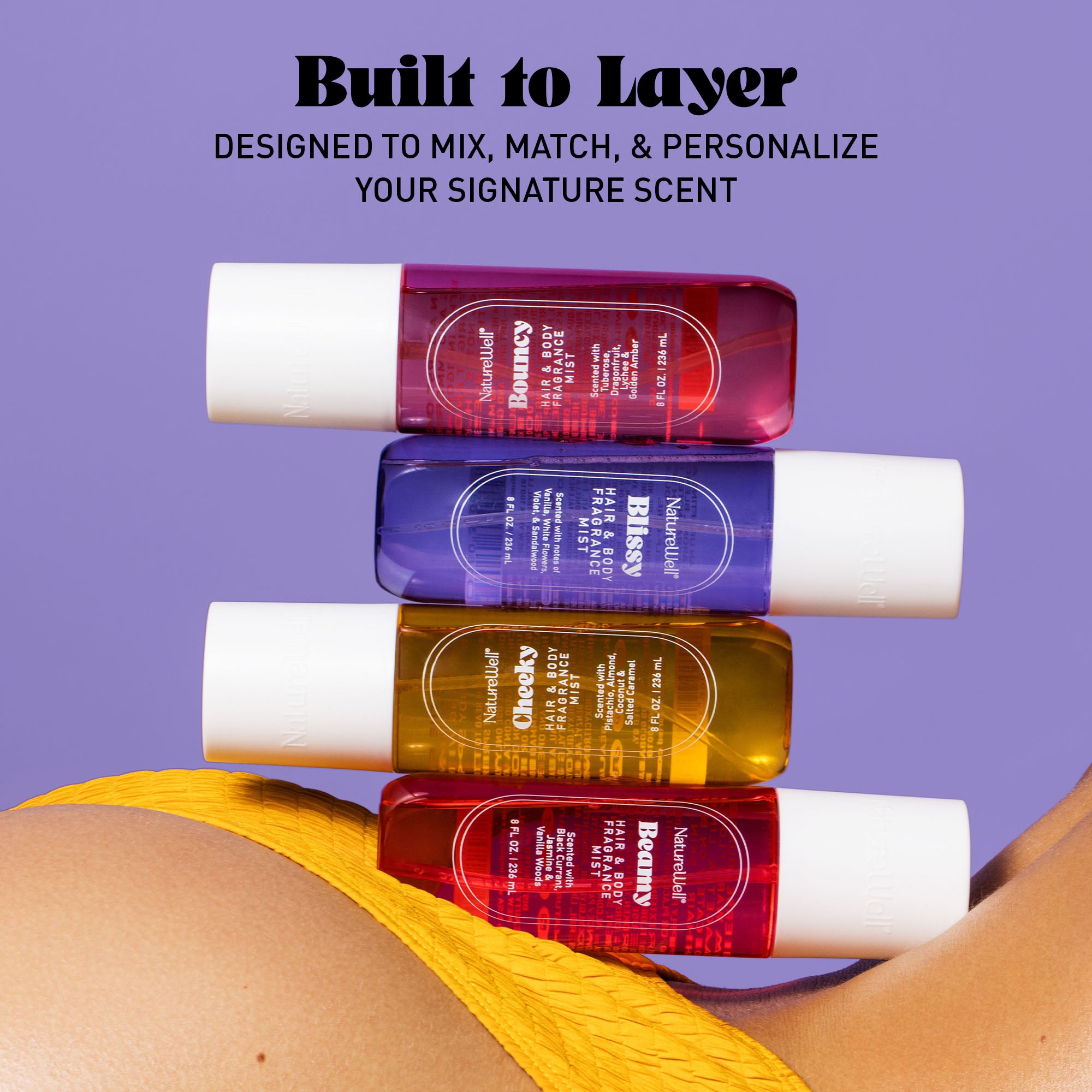 Collection of NatureWell Hair & Body Fragrance Mists on a purple background with text overlay "Built to Layer"