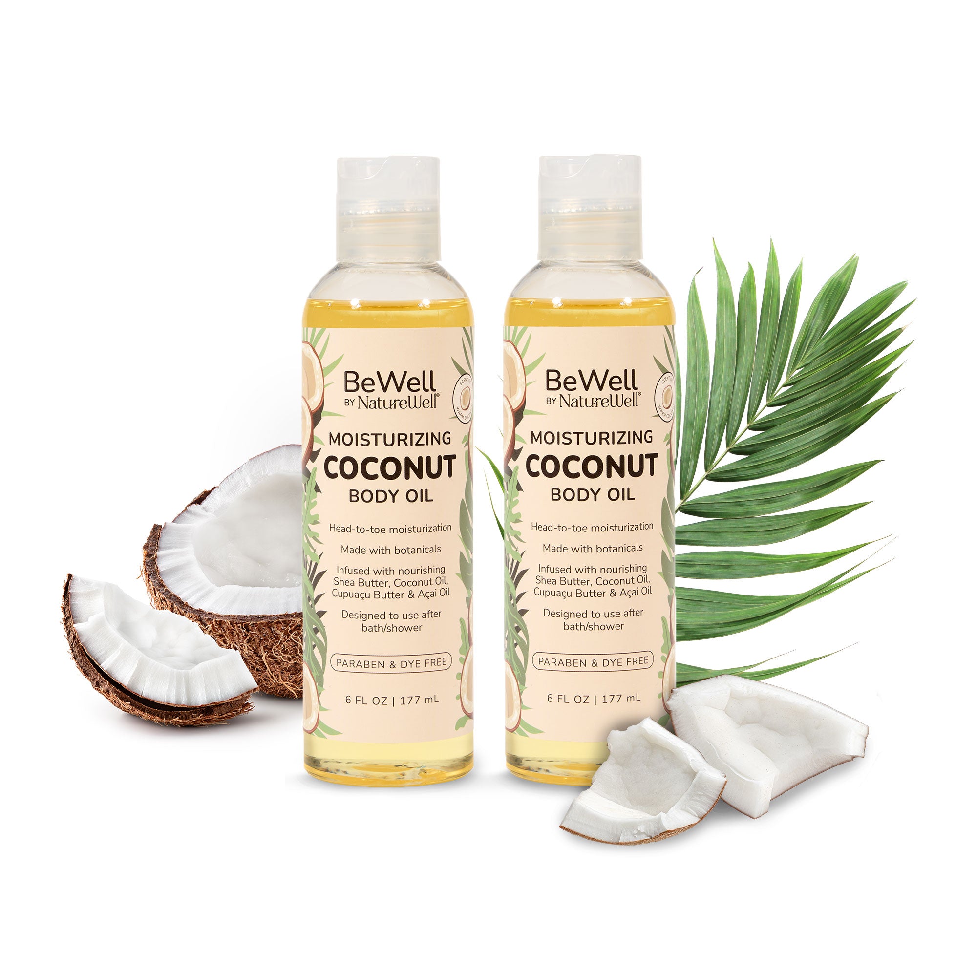 2 bottles of moisturizing coconut body oil next to an open coconut husk with chunks of coconut spread around and green leaves