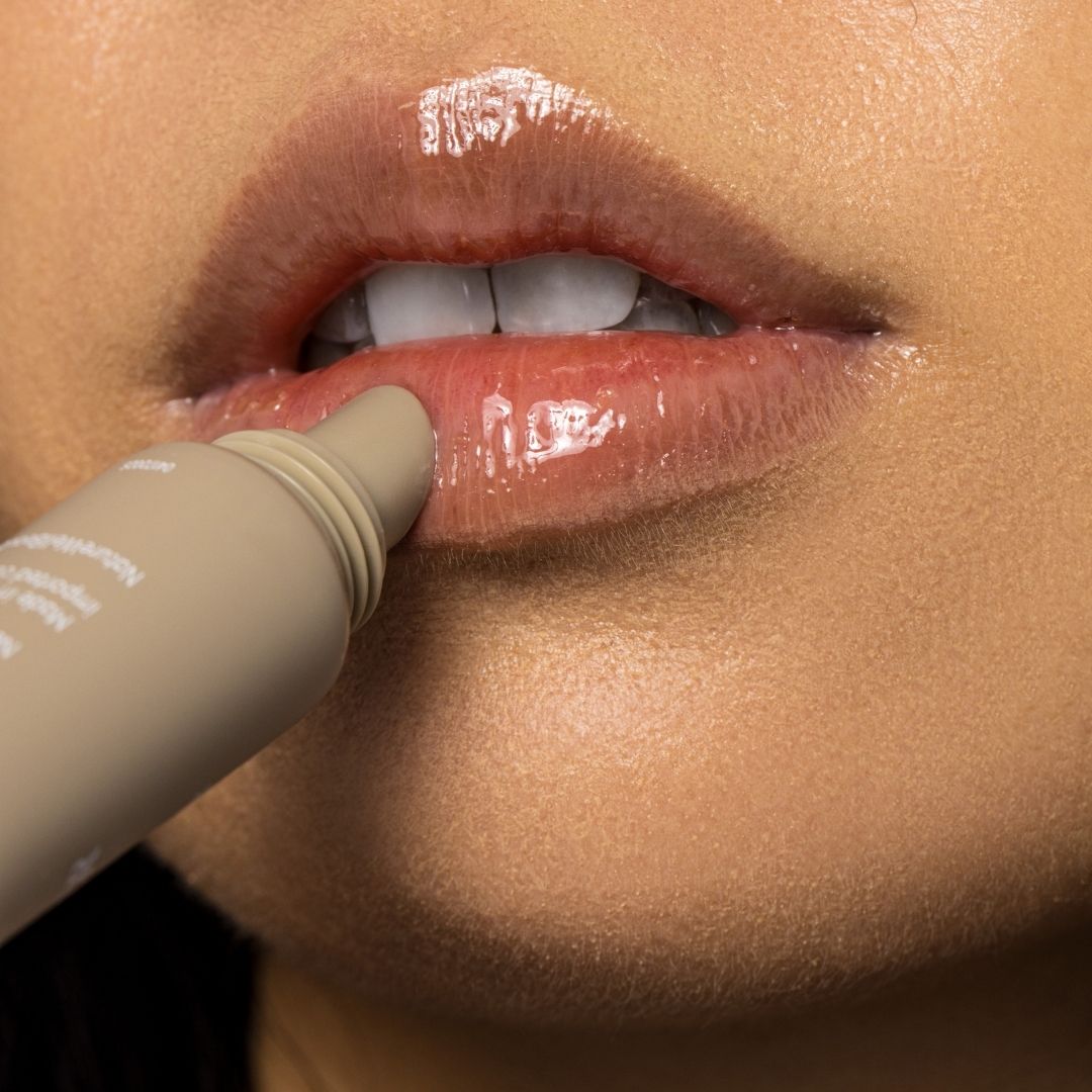 Woman applying NatureWell Tinted Lip Butter in Vanilla Glaze to her lips