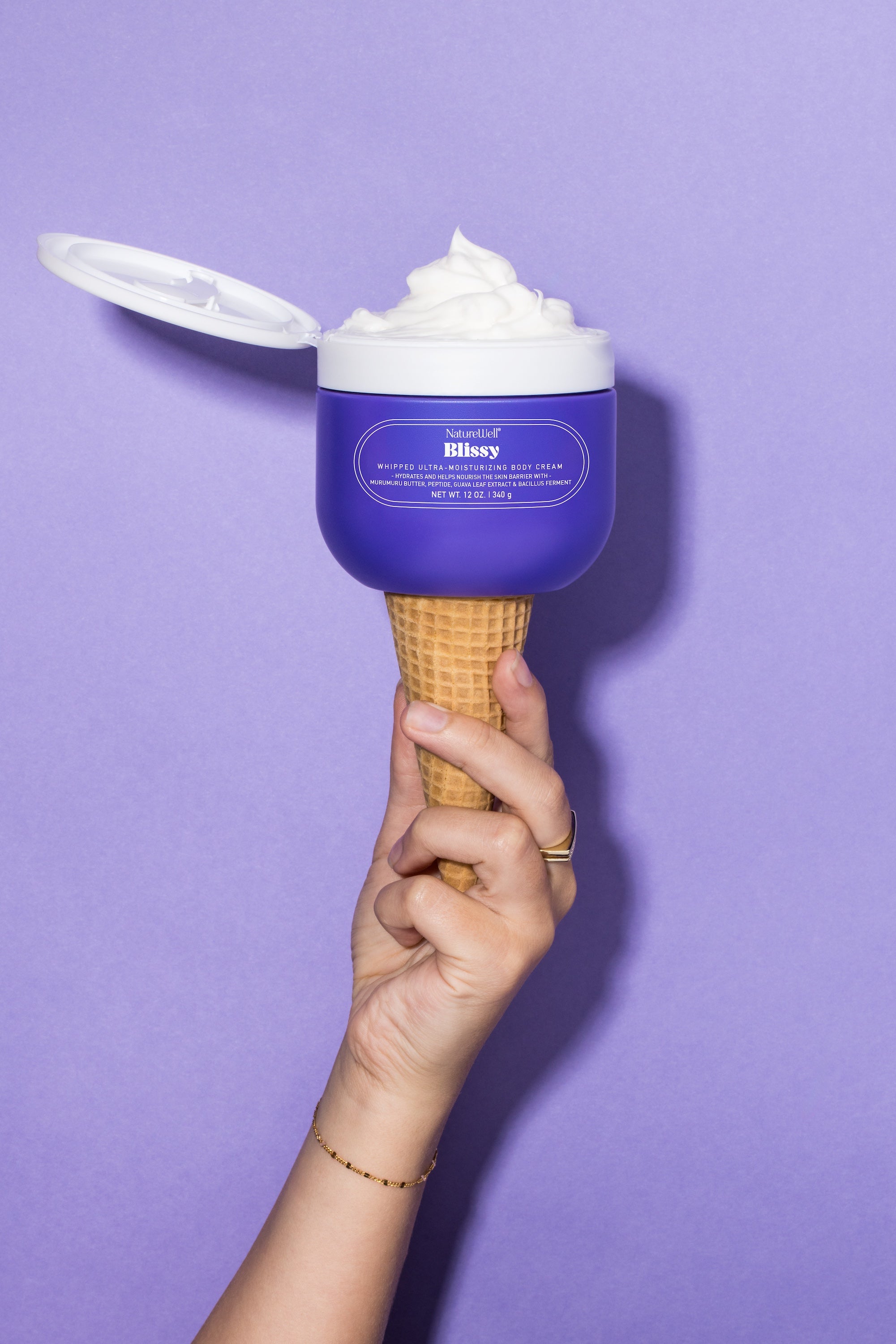 Open jar of NatureWell Blissy Body Cream on a purple background