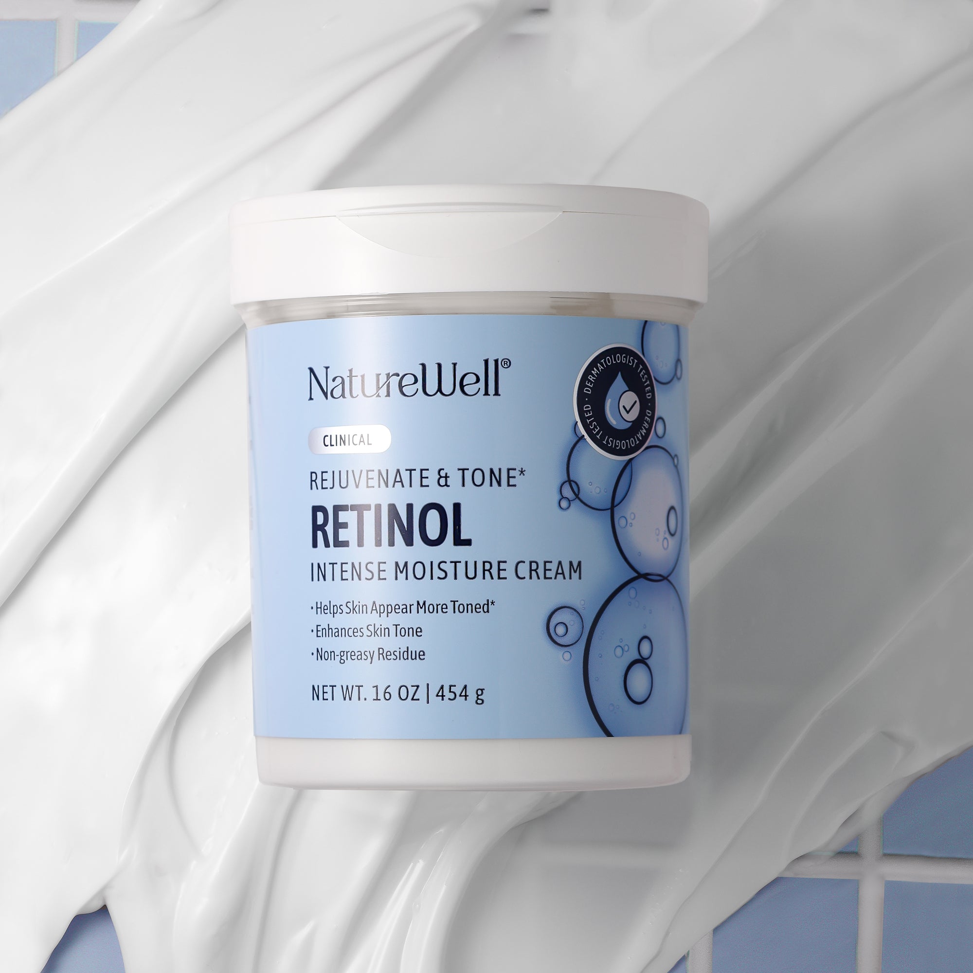 16 ounce jar of retinol moisturizing cream amidst background showing the white, creamy texture of the cream