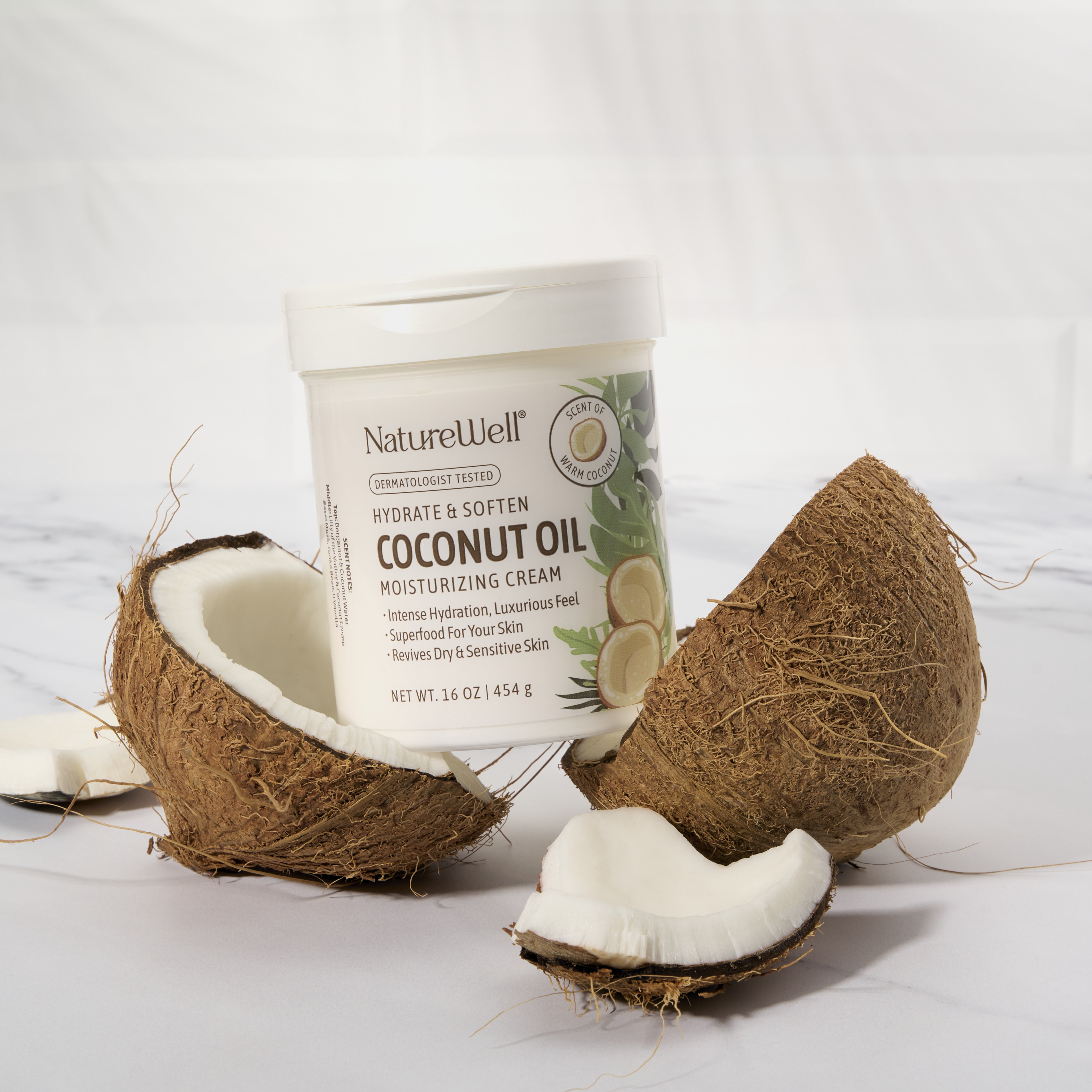16 ounce jar of coconut oil moisturizing cream sitting inside two halves of a opened coconut husk