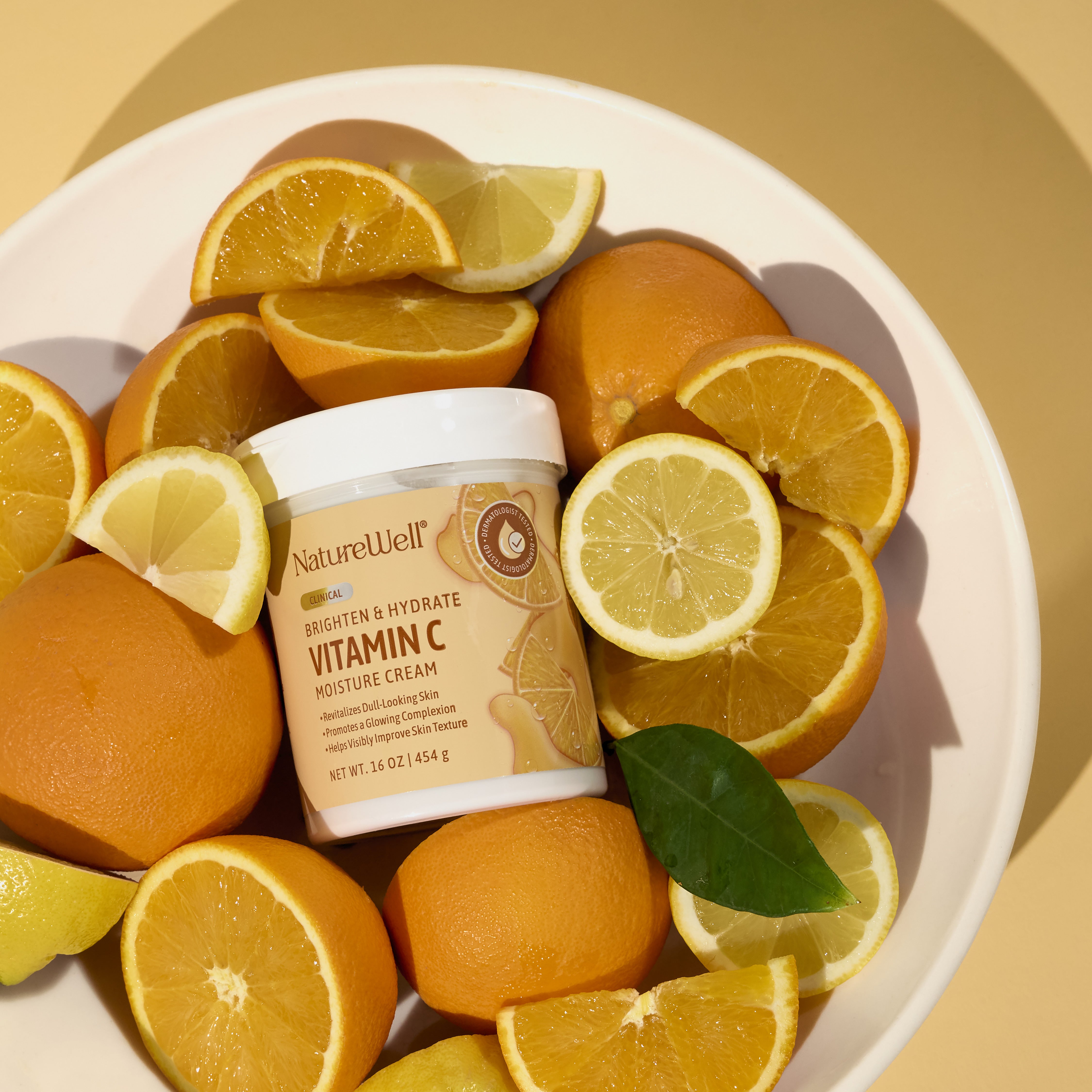 16 ounce jar of vitamin c moisture cream in a bowl with an assortment of citrus fruit