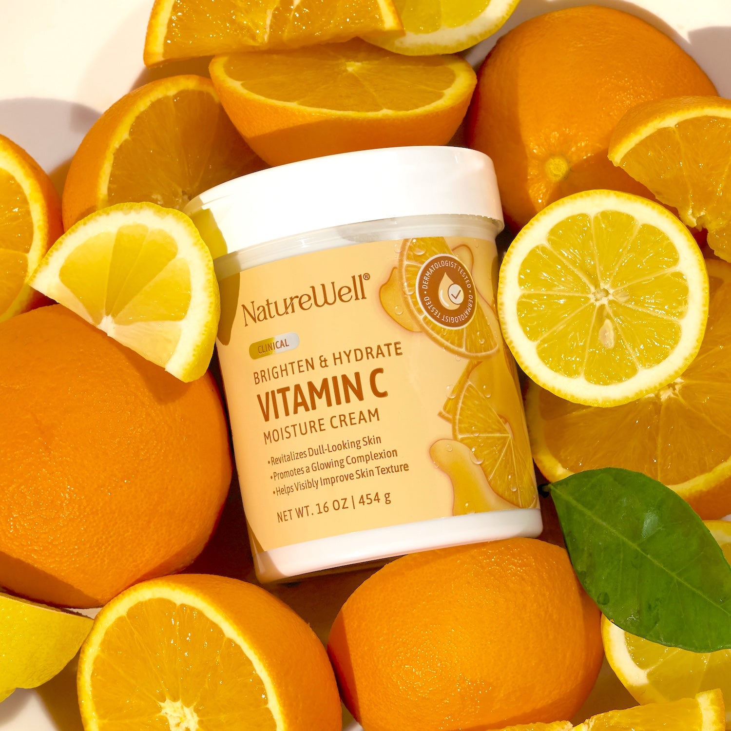 Jar of NatureWell Vitamin C Moisture Cream surrounded by fresh oranges