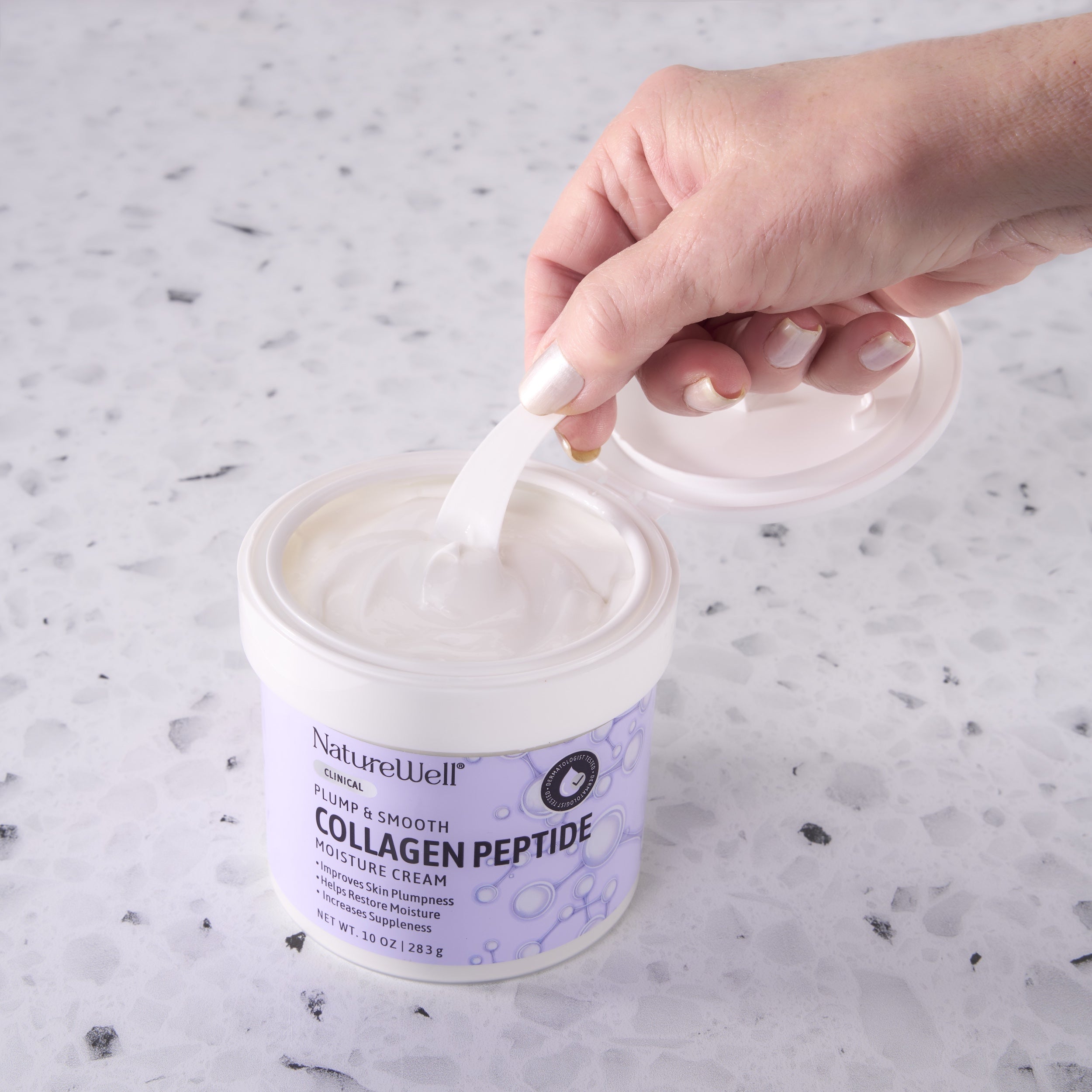 Woman scooping product out of an open jar of NatureWell Collagen Peptide Moisture Cream