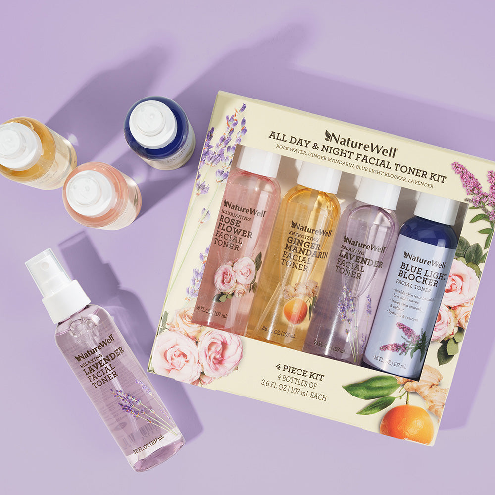 a colorful package containing 4 bottles of facial toner sprays next to 4 loose bottles of toner spray set on a light purple background