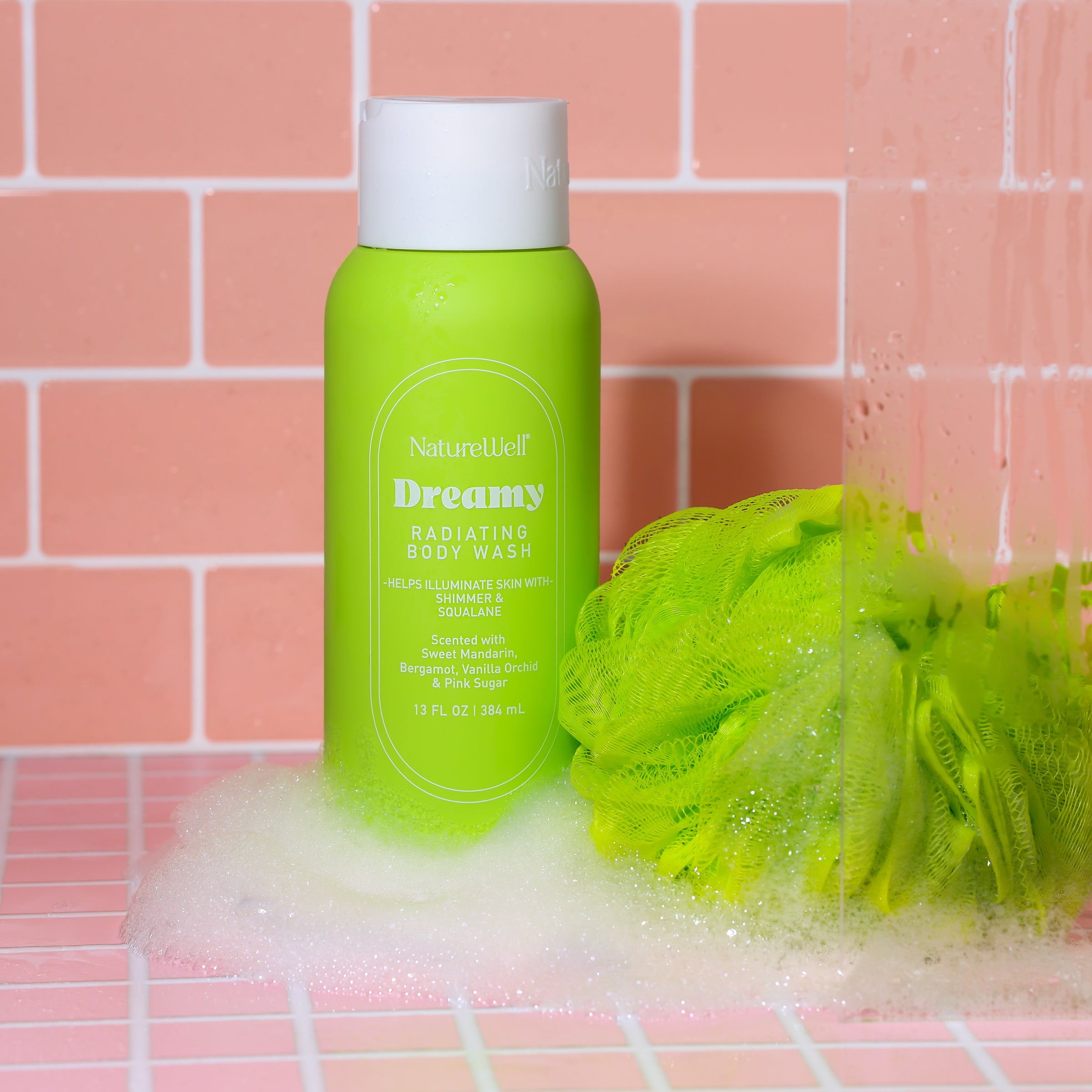 Bottle of NatureWell Dreamy Radiating Body Wash in a pink tiled shower