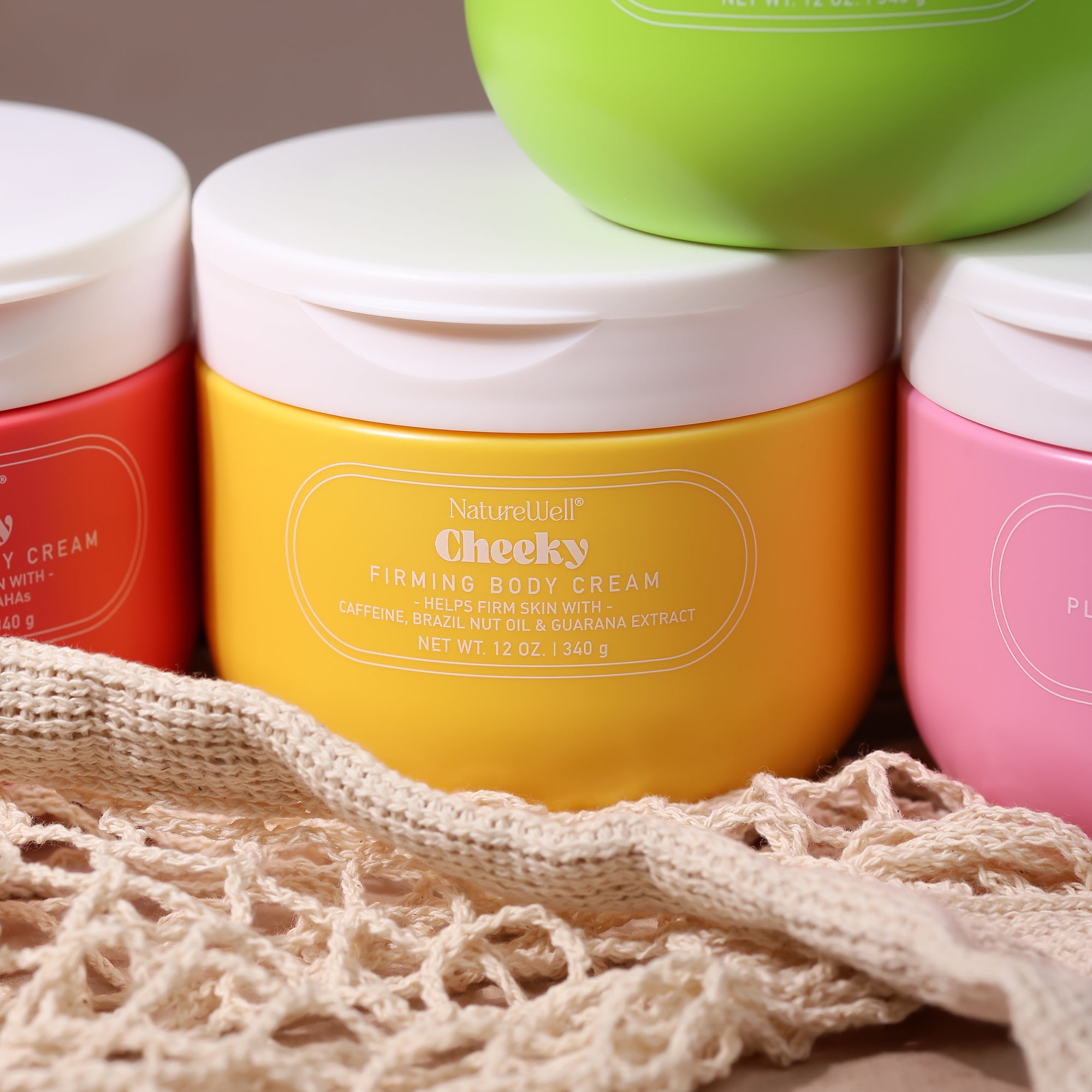 Jar of NatureWell Cheeky Firming Body Cream beside other jars of NatureWell body creams