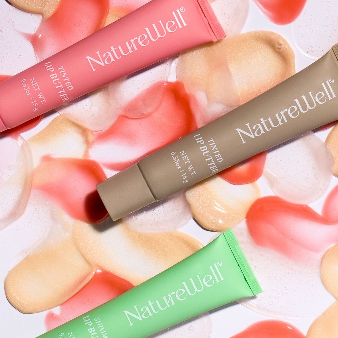 Assortment of 3 tubes of NatureWell Tinted Lip Butters in 3 different shades surrounded by swatches of product