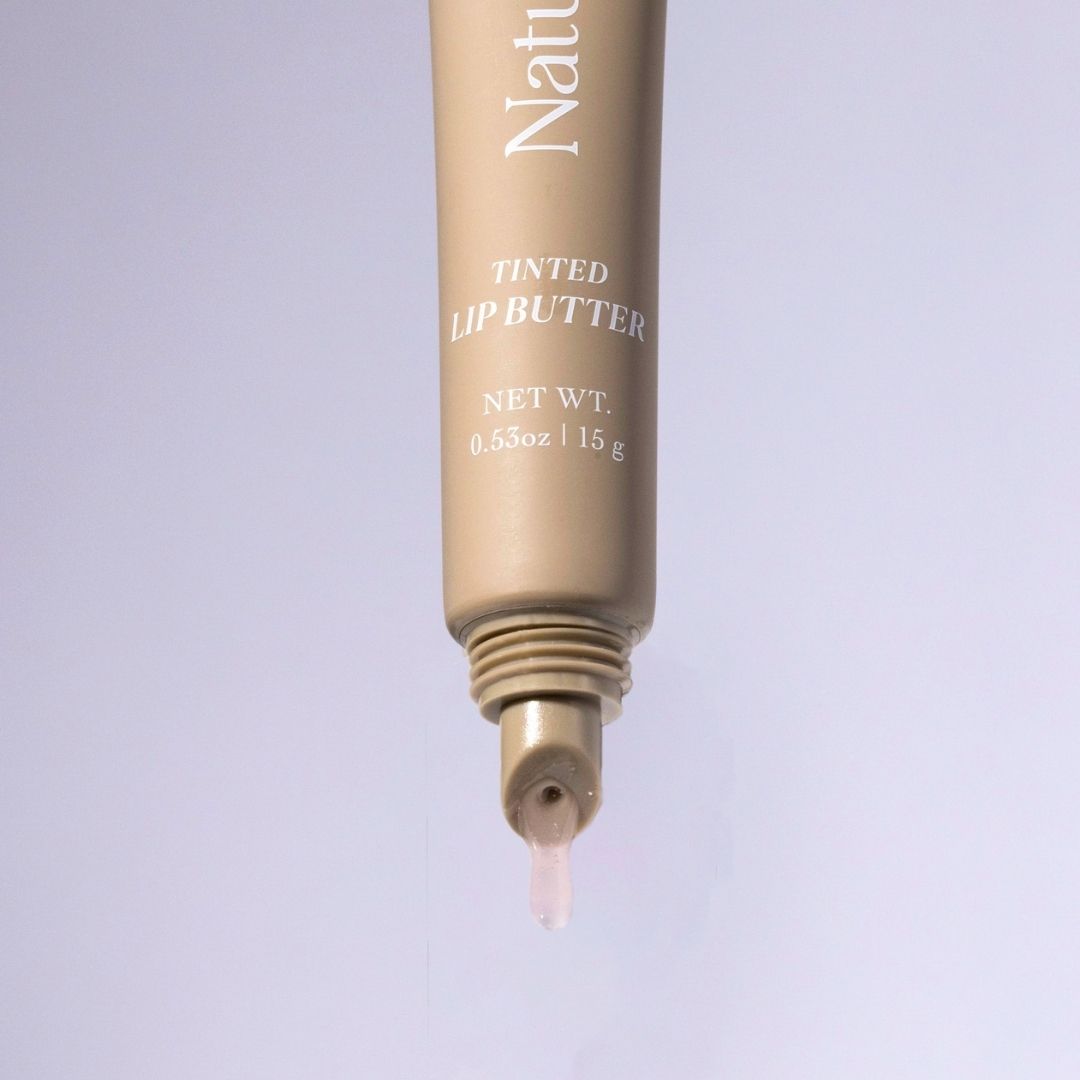 Tube of NatureWell Tinted Lip Butter on a light blue background