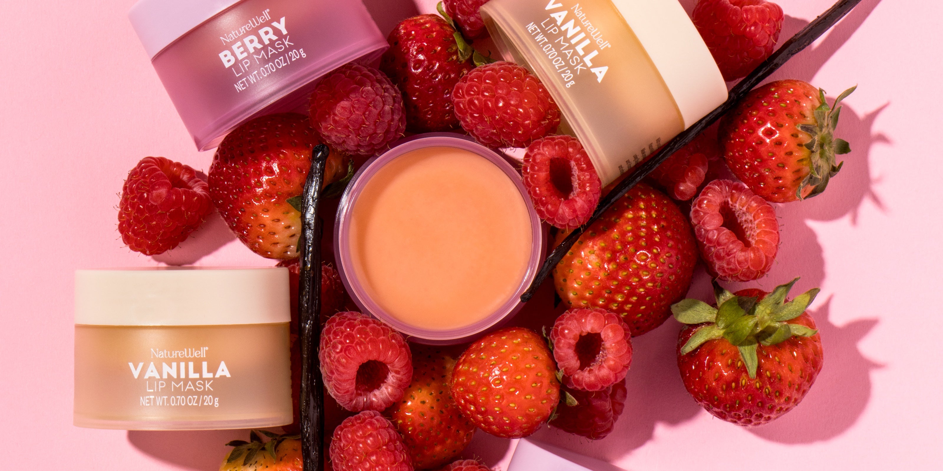 Assortment of NatureWell Lip Masks surrounded by fresh berries and vanilla pods