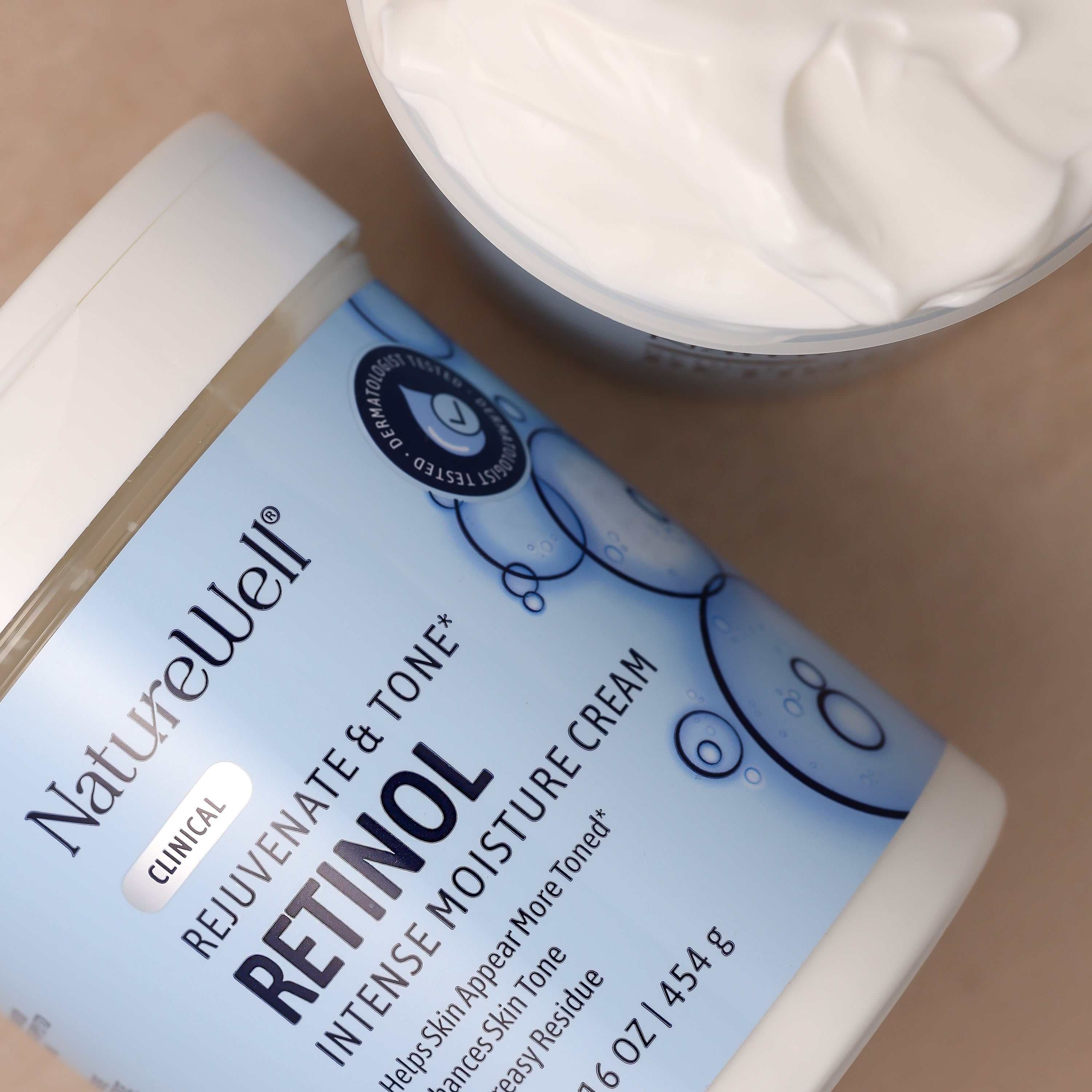 jar of retinol intense moisture cream next to an open jar, showing white, rich texture of cream