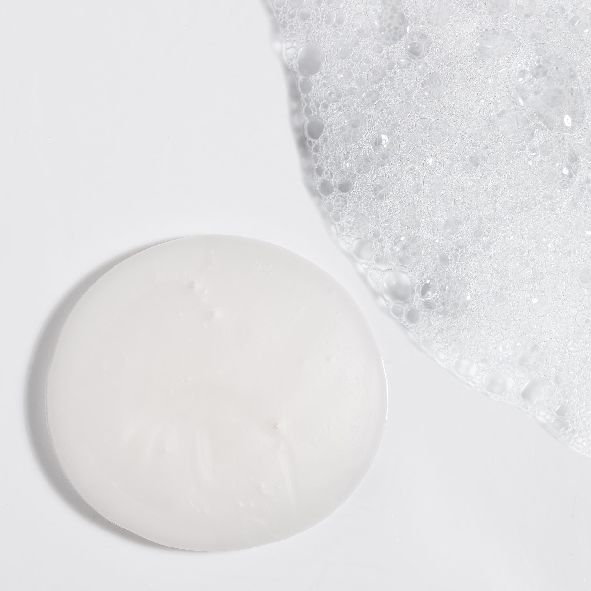 Close-up swatch of NatureWell SunDaze Shampoo and suds on a white background