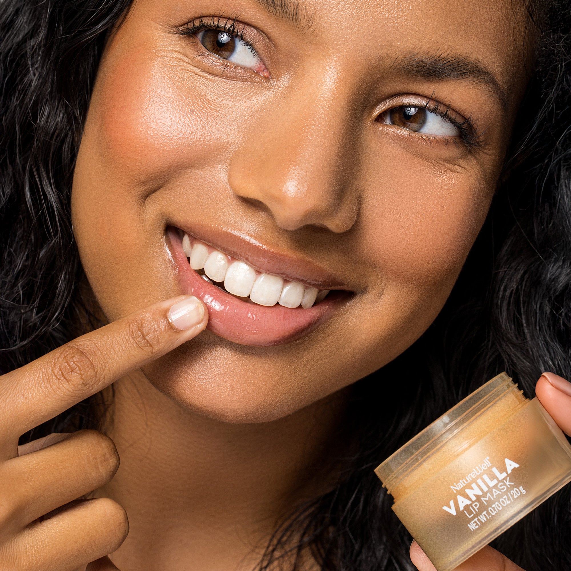 Woman applying NatureWell Vanilla Lip Mask to her lips