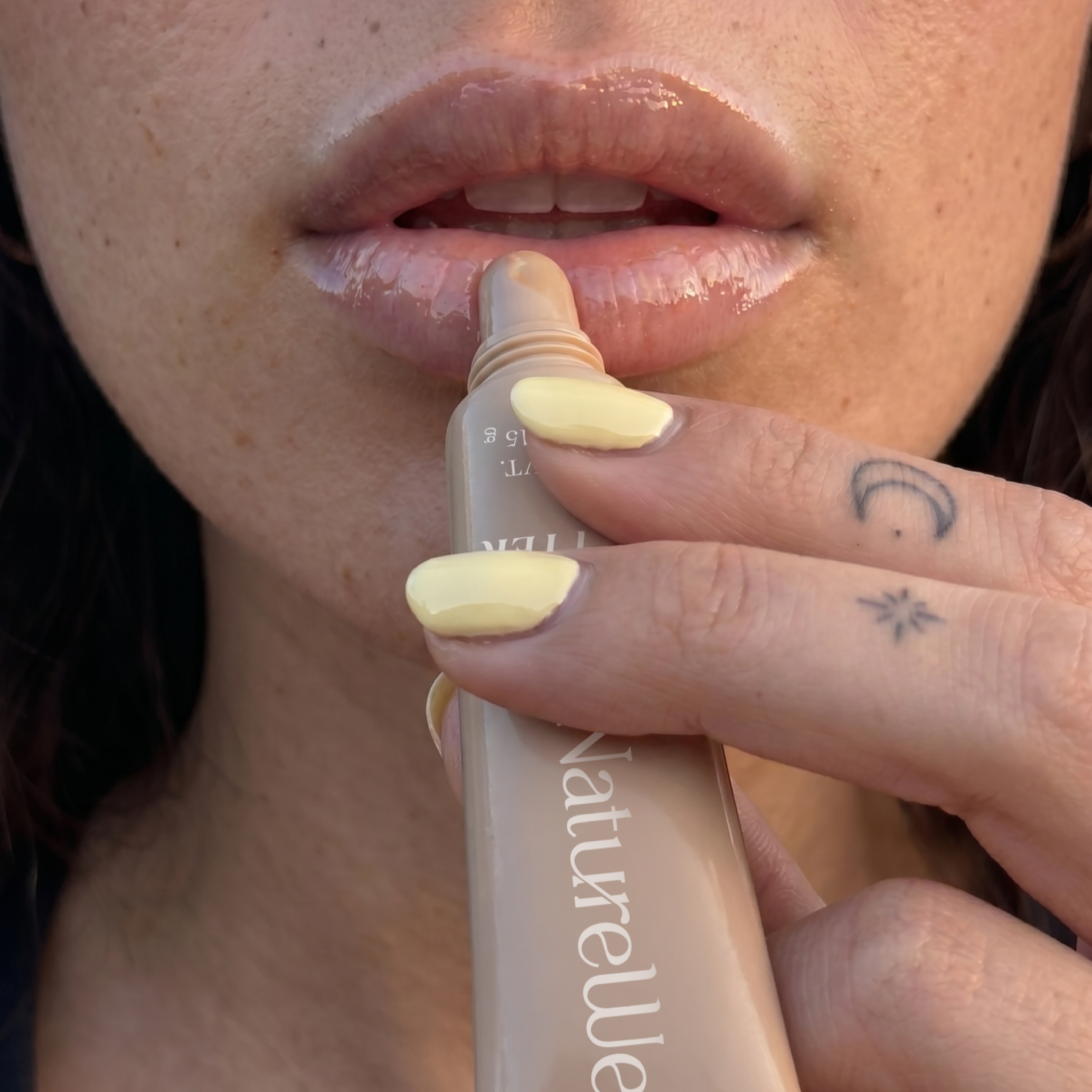 Woman applying NatureWell Lip Butter to her lips