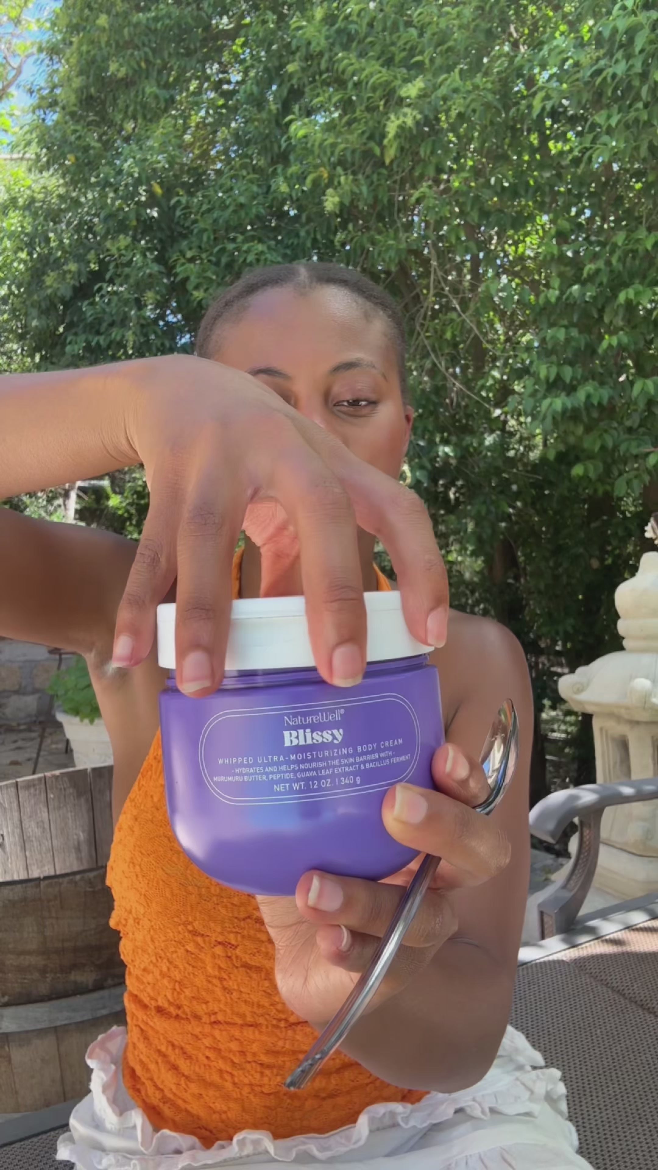 Woman showing her skincare routine using NatureWell Blissy Body Cream