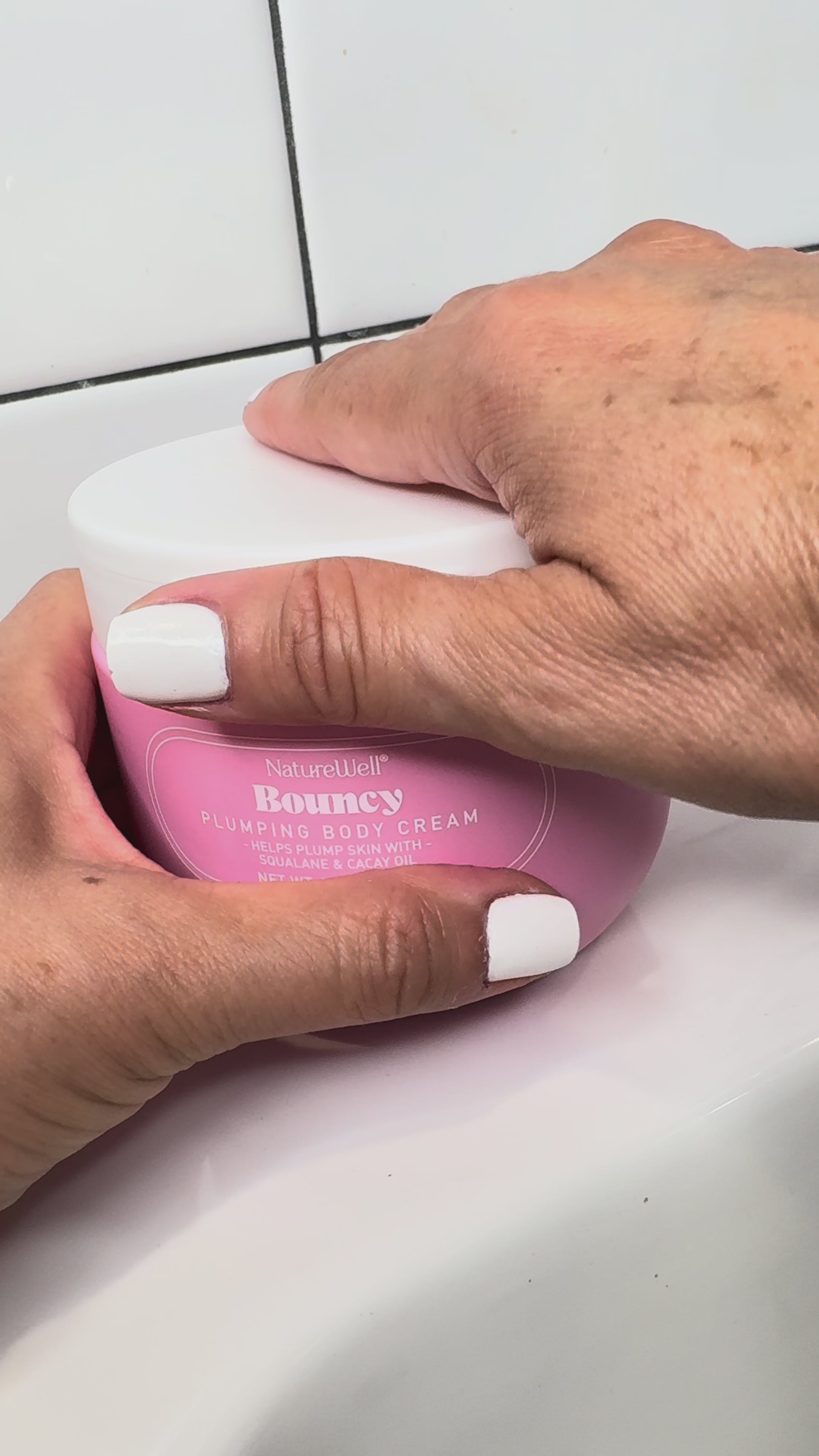 Woman showing her skincare routine using NatureWell Bouncy Plumping Body Cream