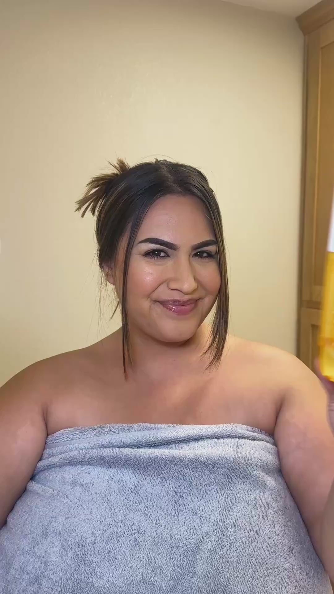 Woman showing her skincare routine using NatureWell Cheeky Firming Body Cream and Cheeky Firming Body Oil